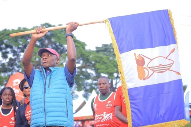 Kabaka Mutebi II holds the Buganda Kingdom flag to see off the runners at Lubiri, Mengo  